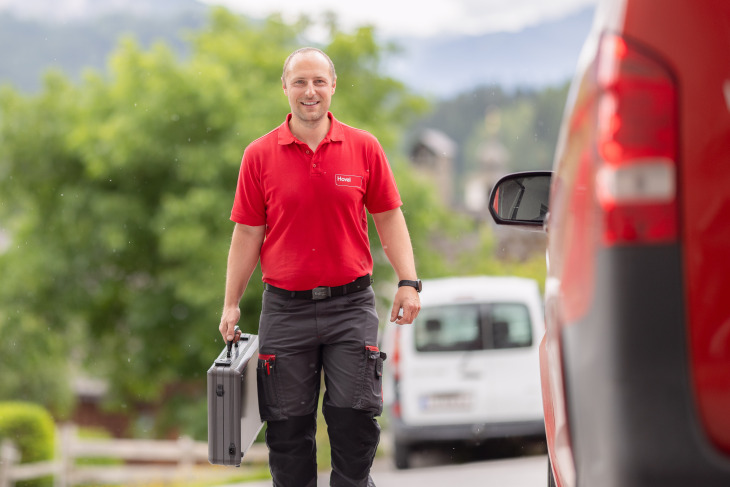 Bild Techniker mit Koffer vor Auto