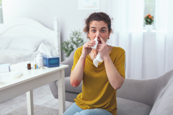 Person mit Allergie schnäuzt sich